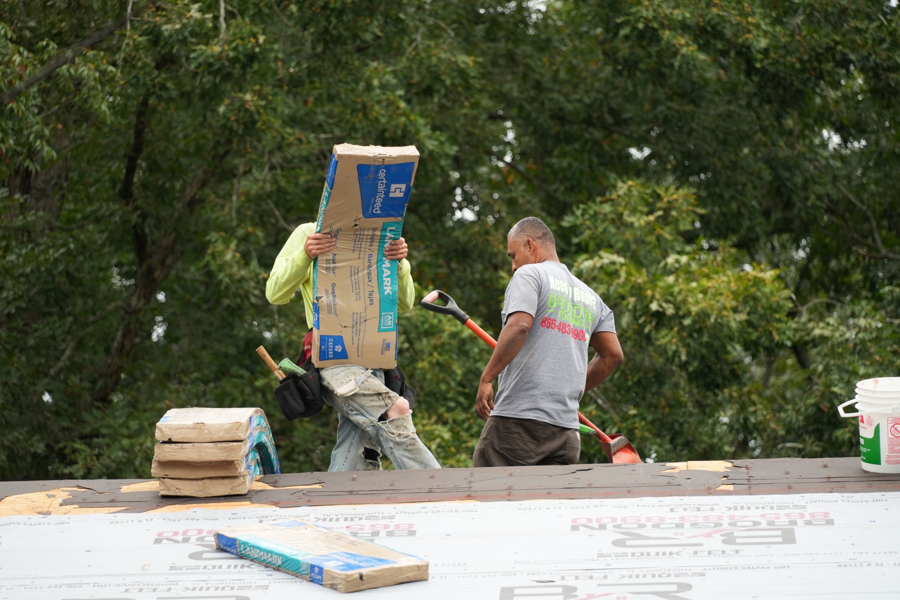 Brogdon crew moving roofing materials into position