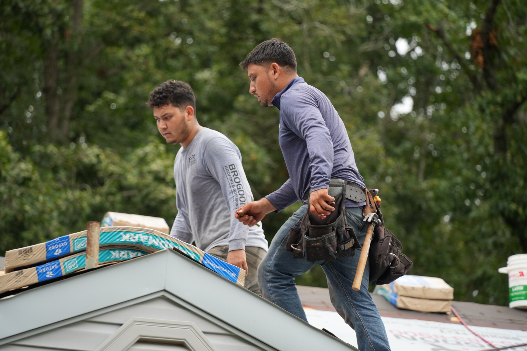Two Brogdon crew members working together on a residential roof